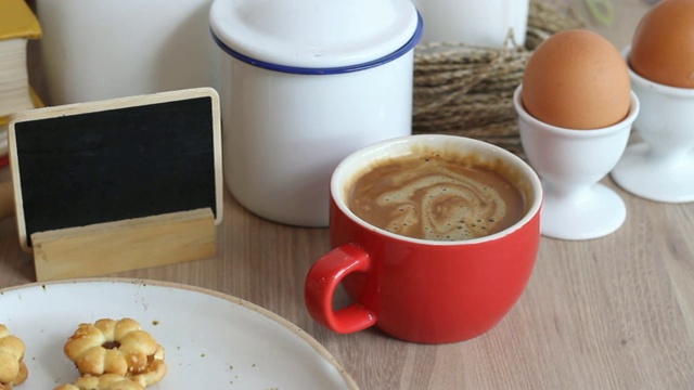 木桌上放着自制面包和热咖啡。