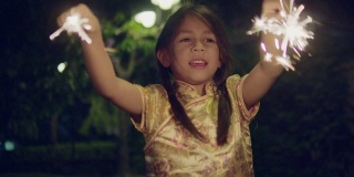 小女孩穿着中式服装，在晚上戴着一个闪闪发光的饰物。