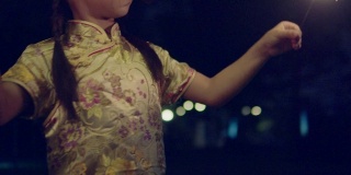小女孩穿着中式服装，在晚上戴着一个闪闪发光的饰物。