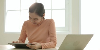 亚洲女性在家里使用平板电脑