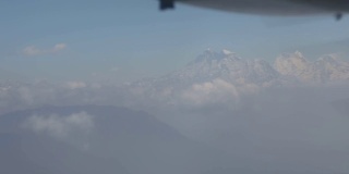 在云上飞行，前景有螺旋桨，远处有喜马拉雅山