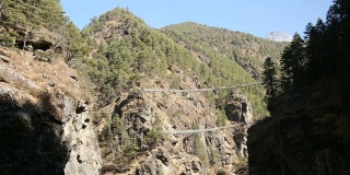 尼泊尔喜玛拉雅山脉中，流动的河流向高处倾斜，形成了一座悬索桥