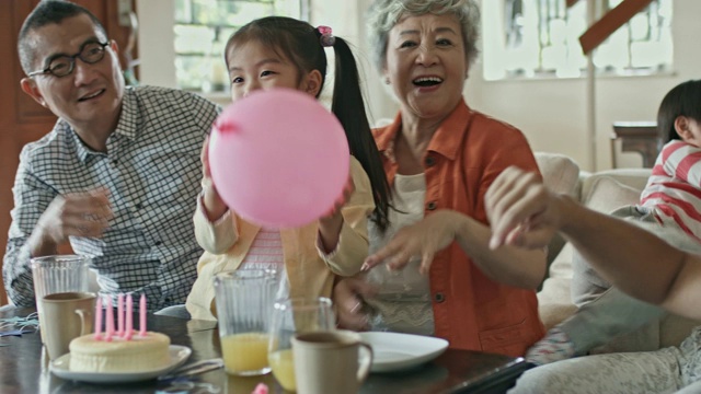 多代同堂的家庭在一个生日派对上玩气球