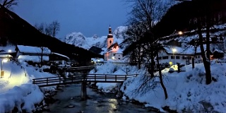 冬天的早晨，在德国巴伐利亚阿尔卑斯山的拉姆绍，贝希特斯加登，著名的圣塞巴斯蒂安教区教堂附近的步行桥。