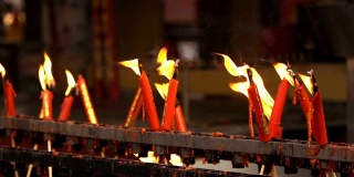 寺庙中红色蜡烛燃烧时火焰的慢镜头