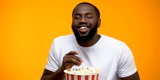 非裔美国人一边吃爆米花一边看有趣的连续剧，特写