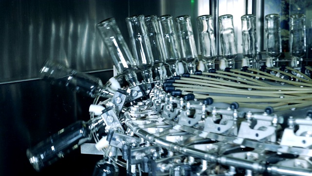 工厂的机械装置降低了玻璃瓶的高度