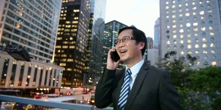 中国商人在香港用移动电话交谈和微笑