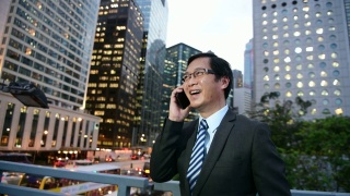 中国商人在香港用移动电话交谈和微笑视频素材模板下载