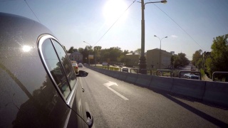 在一个阳光明媚的夏日，汽车在城市的桥上行驶。在车身的一侧。视频素材模板下载