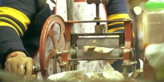 女小贩用研磨机研磨鱿鱼干。