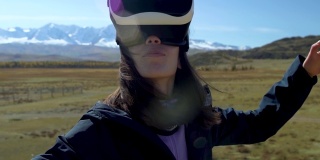 成功的年轻女子，戴着虚拟现实眼镜在雪山中旅行，在夏天度假