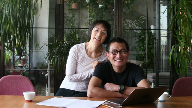 中国夫妇在家里用笔记本电脑做文书工作
