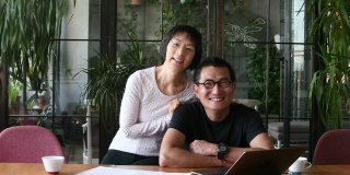 中国夫妇在家里用笔记本电脑做文书工作