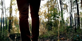 日落时分，他走在秋天的森林里。慢动作