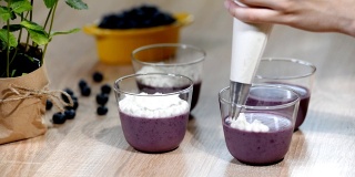 用玻璃杯装饰蓝莓意式奶冻。
