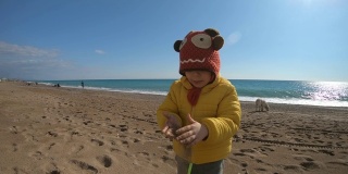 在冬天阳光明媚的日子里，小朋友在沙滩上玩耍。