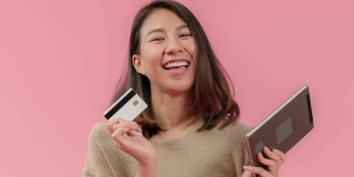 有魅力的年轻亚洲女性在网络应用上使用平板电脑或智能手机购物，使用借记卡，信用卡或银行卡付款，快乐的生活方式与现代金融科技无现金支付。