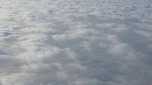 乘飞机旅行。从飞机窗口鸟瞰。美丽的cloudscape。