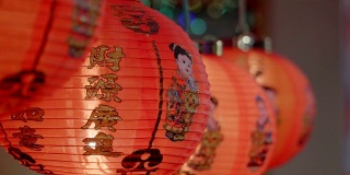中国新年的灯笼装饰在唐人街，文字意味着好运和幸福。