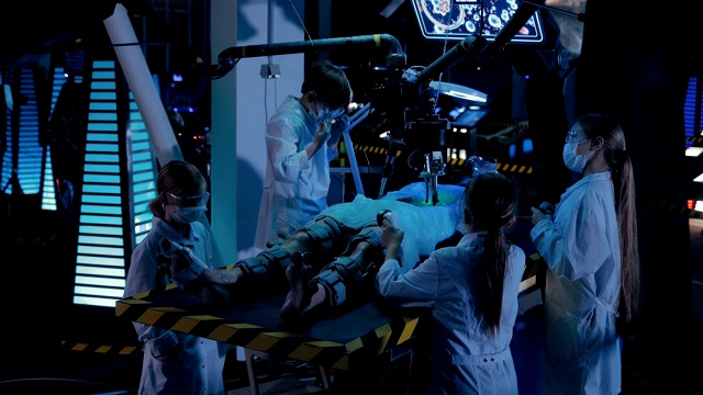 外星人躺在实验室的手术台上。科学家们正在人形动物身上做实验。