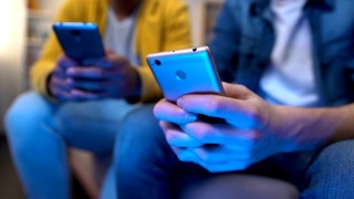男性朋友在手机上玩游戏，用虚拟现实取代了实时交流视频素材模板下载