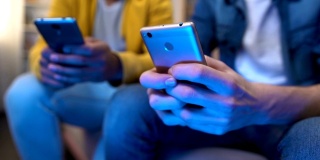 男性青少年朋友在智能手机上赢得多人游戏，沉迷于电子设备