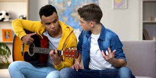 非裔美国少年教白人朋友弹吉他，这是业余爱好