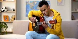 快乐的非洲裔美国少年弹吉他，享受着自己的业余爱好，休闲