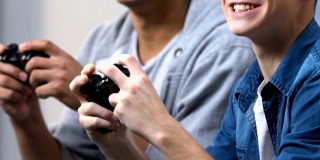 两个年轻的朋友欢呼和庆祝赢得电子游戏，最喜欢的爱好