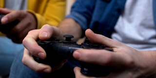 两个十几岁的男孩在玩快节奏的电子游戏，赢得和握紧拳头