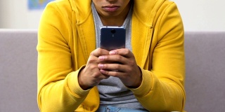 非裔美国男孩在智能手机上快速打字，和朋友在网上聊天