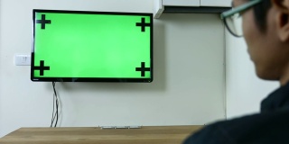 男子观看绿色模拟屏幕电视