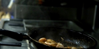 Сhef在厨房准备虾在热锅上撒上香料和酱汁