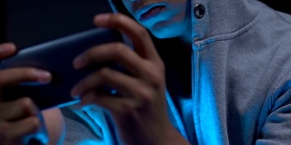 美国黑人男孩晚上在智能手机上玩飞行模拟器手机游戏