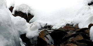 登山者在冬季跳过小溪。