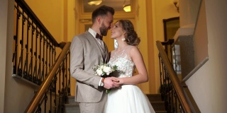 一对美丽的新婚夫妇在时髦昂贵的室内台阶上摆姿势