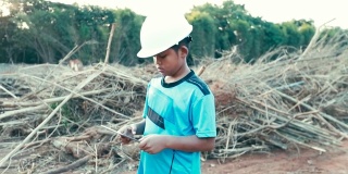 小男孩亚洲与工程师帽一个使用数字表，概念我的梦想工程师，慢动作