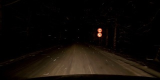 POV在晚上行驶在积雪覆盖的道路上，在暴风雪的夜晚