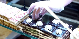 特写的一个糖果商在手套把蛋糕在超市柜台上