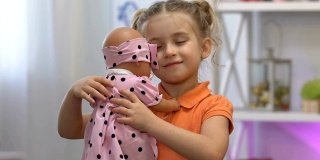 可爱的女孩温柔地抱着心爱的婴儿玩具，梦见小妹妹