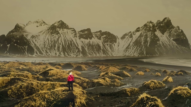 以韦斯特拉霍恩山脉为背景的成熟女人探索斯托克尼斯海滩的全景