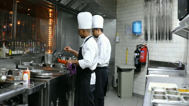 印度厨师在一个美食餐厅的专业厨房烹饪