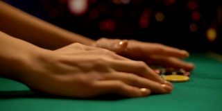 贪婪的女性扑克玩家从桌子上拿赌博筹码，赢得游戏