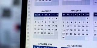 在电脑上浏览日历的人，为未来的一年做计划