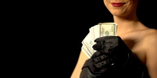 女士抚摸她的身体与美元现金，彩票或赌场获胜的概念