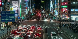 在日本东京新宿，一群不明身份的人在人行道上行走。日本霓虹街文化与购物概念