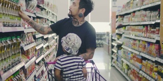 一个带着小男孩在杂货店的年轻人