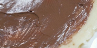 手抹榛子奶油煎饼纹理特写4K 2160p 30fps超高清倾斜镜头-巧克力顶部准备滚上美味的甜3840X2160超高清视频