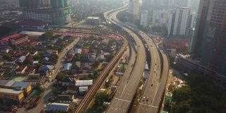 鸟瞰图吉隆坡市区，马来西亚和高速公路。亚洲智慧城市的金融区和商业中心。摩天大楼和高楼大厦中午与蓝天。